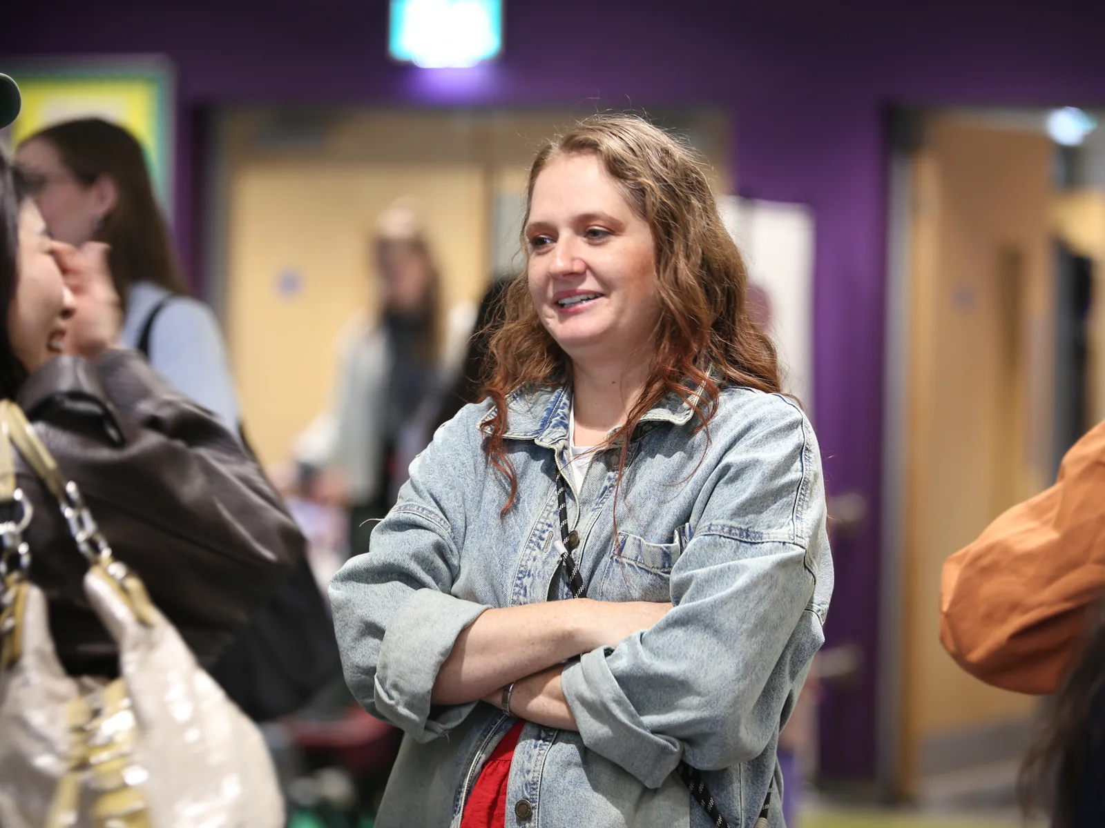 A woman smiling and chatting in the foyer at C3 Liverpool on a Sunday morning